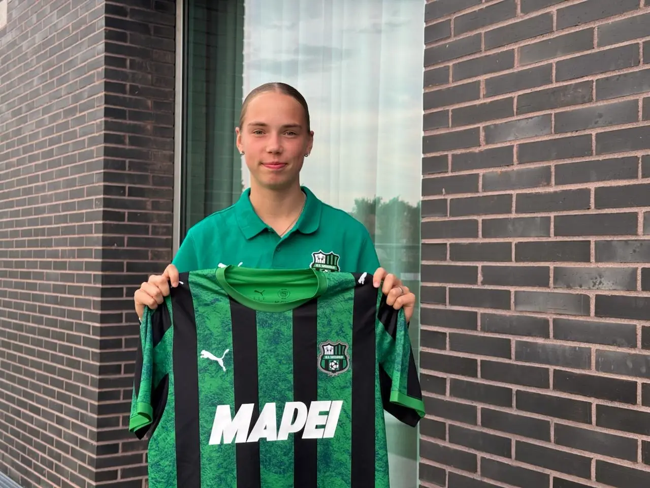 Emīlija Ambaine holding a U.S. Sassuolo shirt